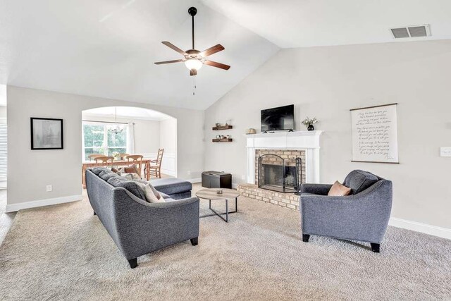 living room featuring arched walkways, ceiling fan, carpet floors, a fireplace, and high vaulted ceiling