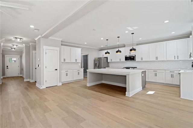 kitchen with a center island, crown molding, stainless steel appliances, light wood-style floors, and white cabinetry