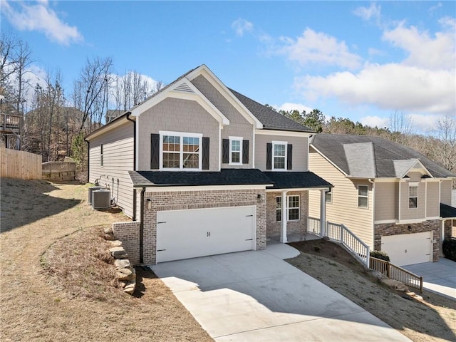 view of front of home with driveway, central AC unit, an attached garage, fence, and brick siding