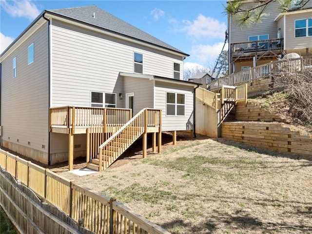 rear view of house with fence private yard, a shingled roof, stairs, a yard, and a wooden deck