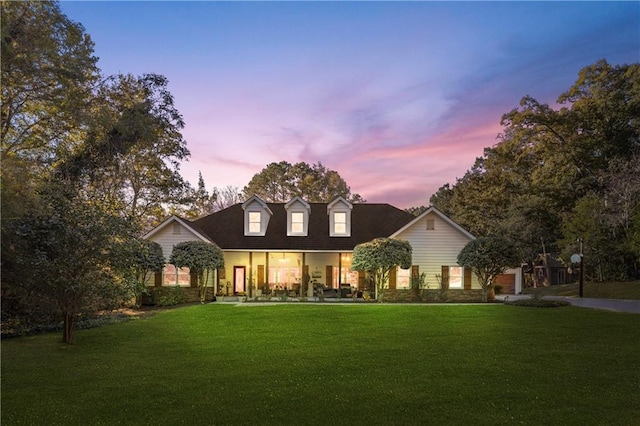 new england style home with a lawn and a porch