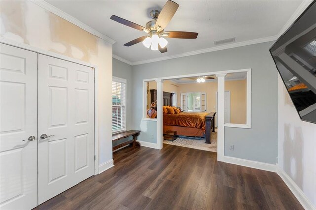 bedroom featuring dark hardwood / wood-style flooring, decorative columns, ceiling fan, crown molding, and a closet