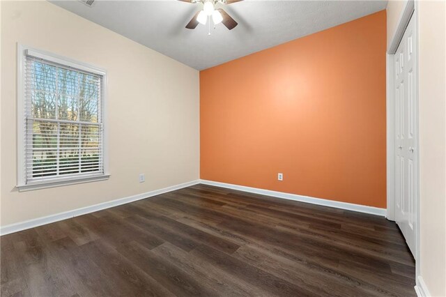 unfurnished bedroom with lofted ceiling, ceiling fan, a closet, and dark hardwood / wood-style floors