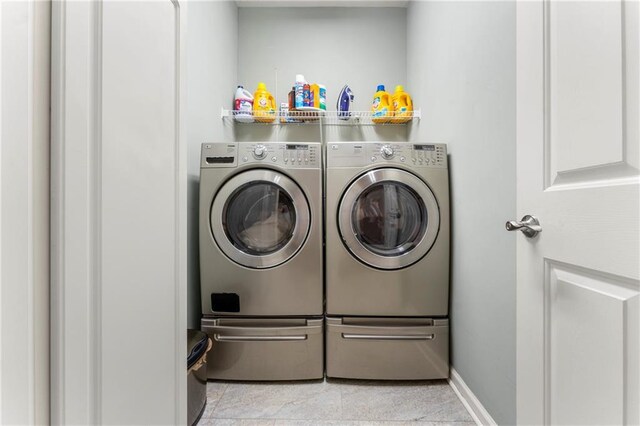 laundry room with washing machine and dryer and light tile patterned floors