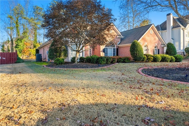 view of front of house with a front yard and central AC unit