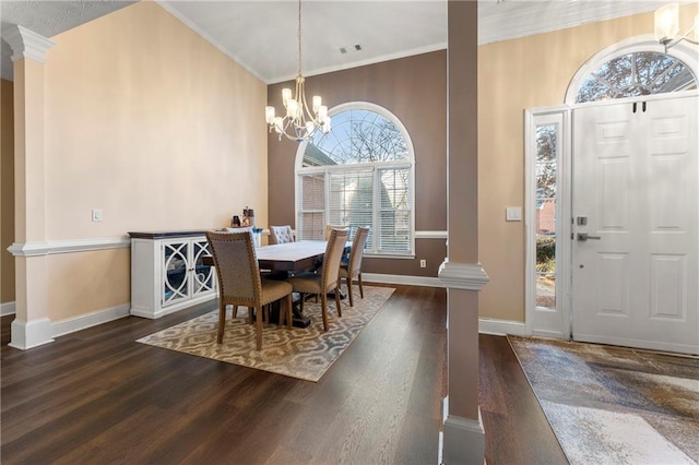 dining space with dark hardwood / wood-style floors, ornate columns, and a wealth of natural light