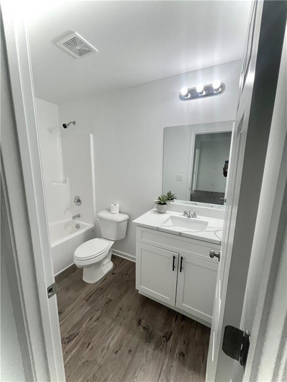 full bathroom with wood-type flooring, vanity, toilet, and shower / bathtub combination