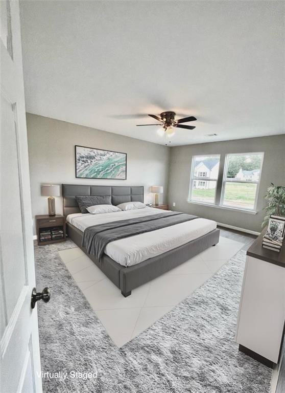 tiled bedroom featuring ceiling fan