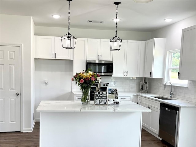 kitchen featuring white cabinets, a center island, hanging light fixtures, and appliances with stainless steel finishes