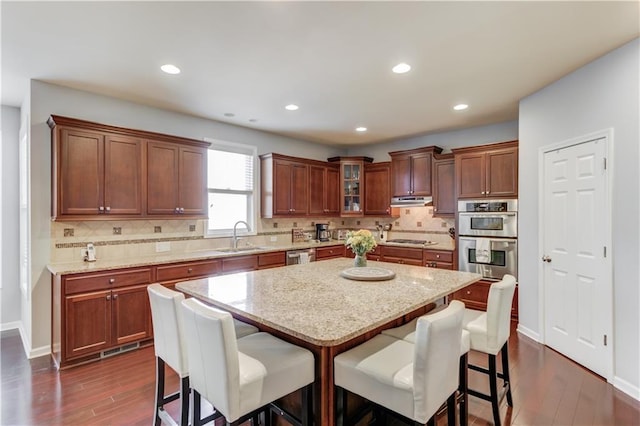 kitchen with sink, a kitchen island, a breakfast bar area, and appliances with stainless steel finishes