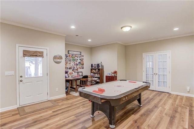 playroom featuring crown molding, french doors, and light wood-type flooring