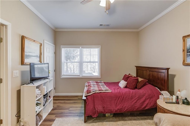 bedroom with hardwood / wood-style flooring, ornamental molding, and ceiling fan