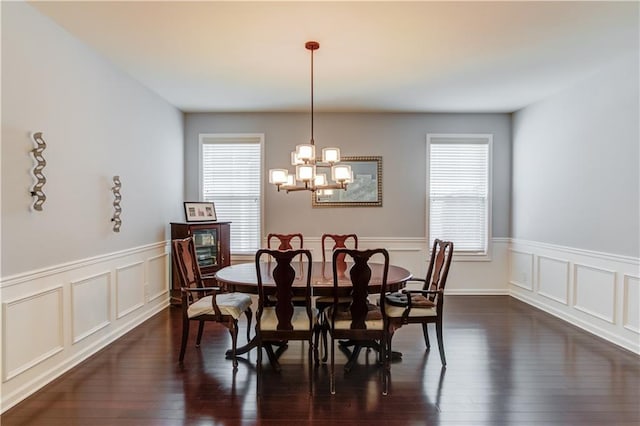 dining area with dark hardwood / wood-style floors and a notable chandelier