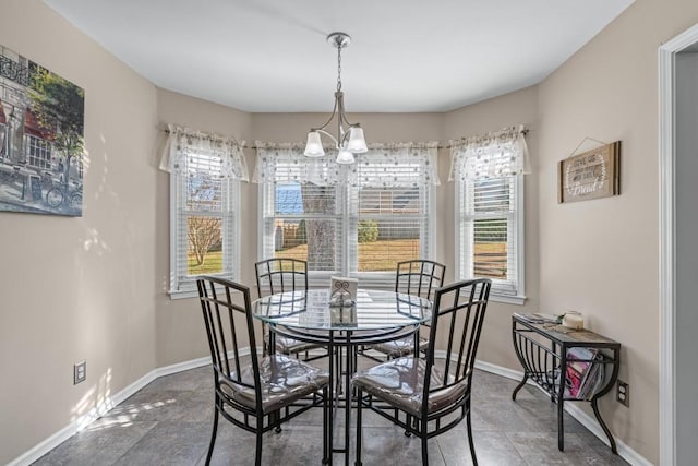 dining space featuring baseboards and a chandelier