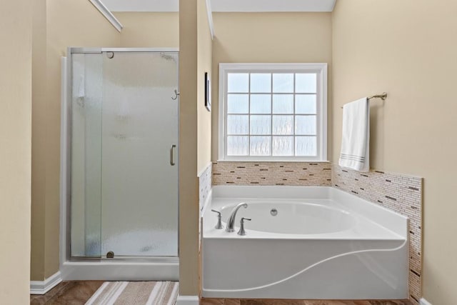 bathroom featuring a garden tub and a shower stall