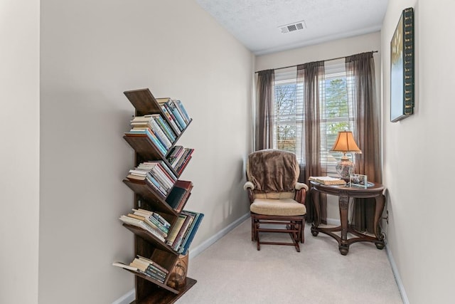 sitting room with carpet, visible vents, and baseboards