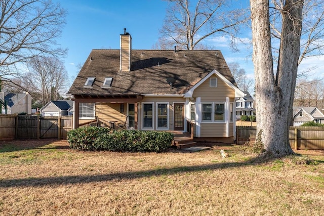 back of house with a yard, fence, and a chimney