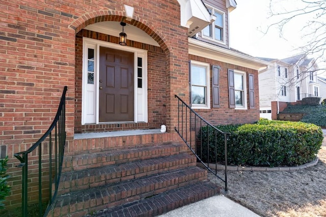 entrance to property featuring brick siding