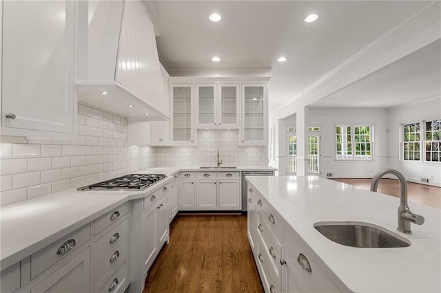 kitchen featuring white cabinets, stainless steel gas stovetop, backsplash, and sink