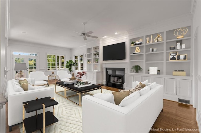 living room featuring french doors, ceiling fan, crown molding, and built in features