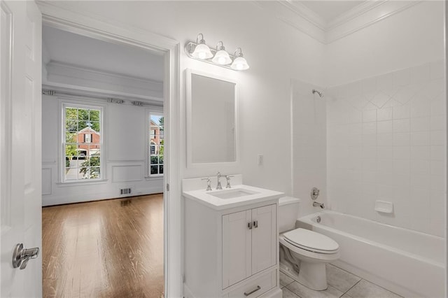 full bathroom with hardwood / wood-style flooring, toilet, vanity, tiled shower / bath combo, and crown molding