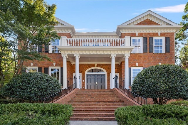 greek revival inspired property featuring a balcony