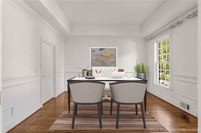 dining room featuring dark wood-type flooring, a tray ceiling, and crown molding