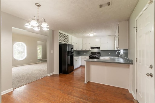 10 Briarcliff Pl, Stockbridge, GA 30281 - kitchen featuring black appliances, a peninsula, open floor plan, a textured ceiling, and decorative backsplash