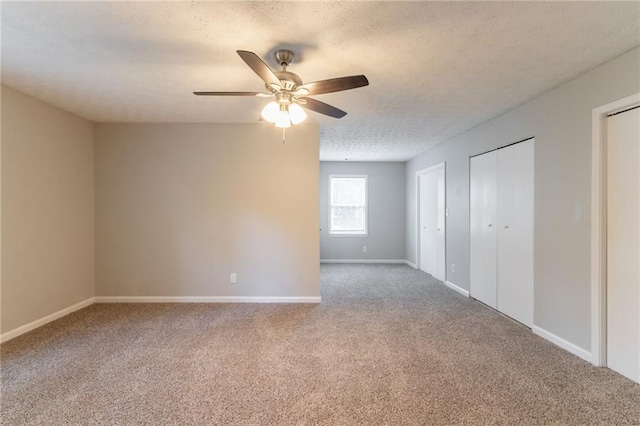 10 Briarcliff Pl, Stockbridge, GA 30281 - unfurnished bedroom with multiple closets, carpet flooring, a textured ceiling, and ceiling fan