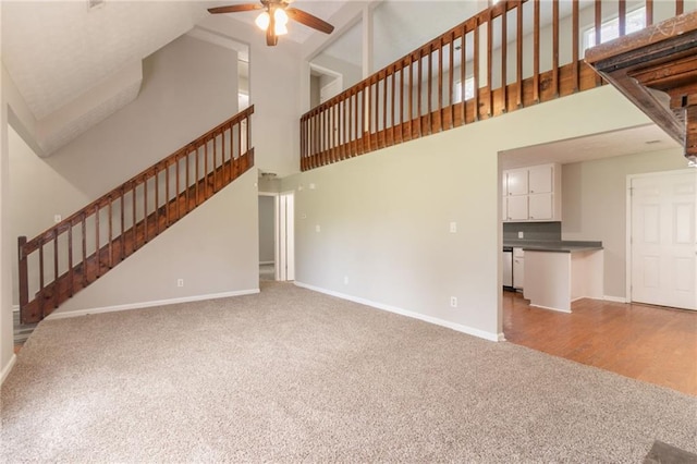 10 Briarcliff Pl, Stockbridge, GA 30281 - unfurnished living room featuring carpet flooring, a high ceiling, a ceiling fan, and stairs