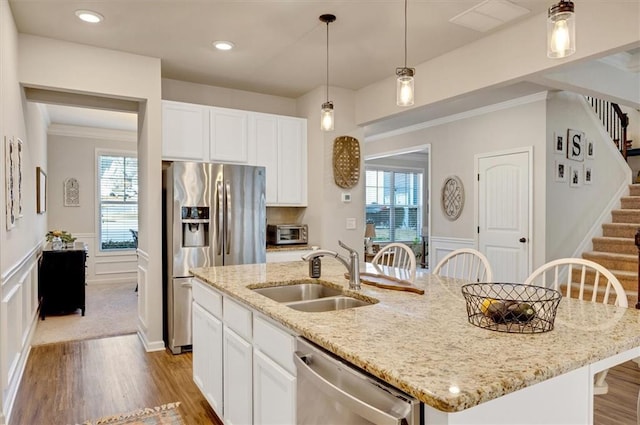 kitchen with sink, a center island with sink, white cabinetry, and appliances with stainless steel finishes