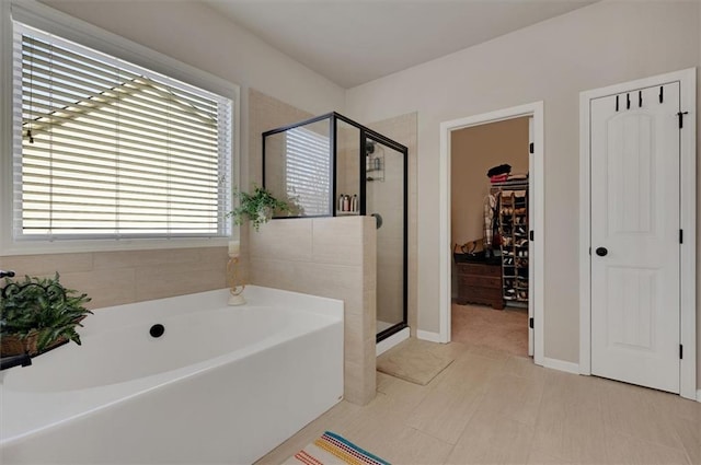 bathroom with tile patterned floors and shower with separate bathtub