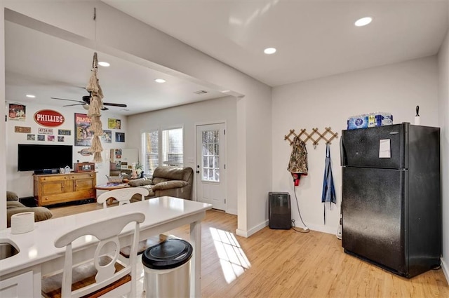 kitchen with black refrigerator, ceiling fan, and light hardwood / wood-style flooring