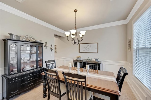 dining room with an inviting chandelier, ornamental molding, and light carpet