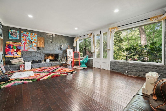 living area featuring ornamental molding, a fireplace, wood finished floors, and recessed lighting