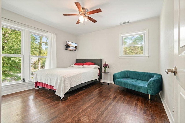 bedroom featuring baseboards, multiple windows, hardwood / wood-style flooring, and a ceiling fan