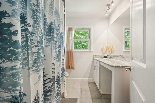 bathroom with vanity, tile patterned floors, and baseboards