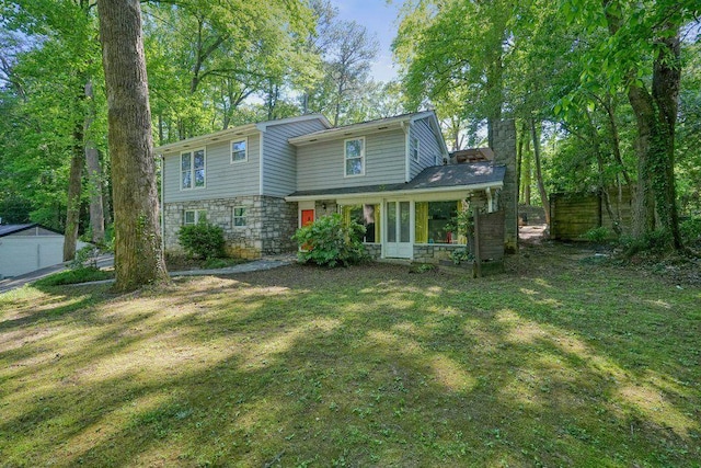 rear view of property with stone siding, a yard, and a sunroom