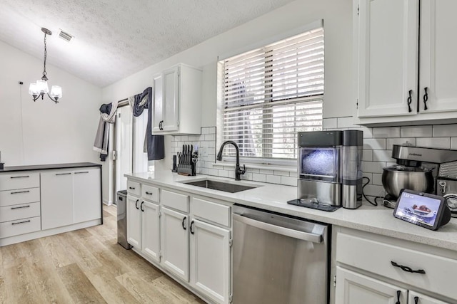 kitchen with visible vents, light wood-type flooring, a sink, stainless steel dishwasher, and white cabinets