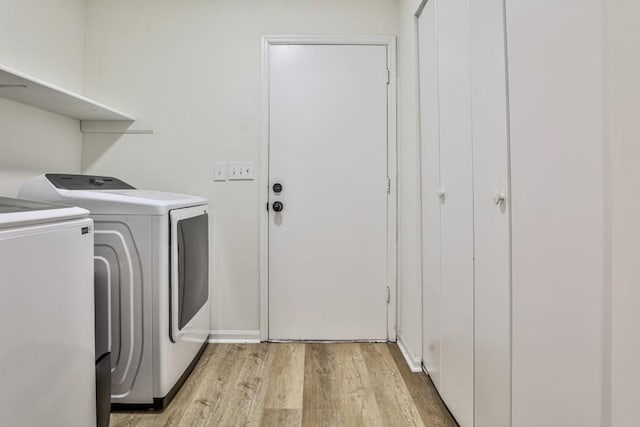 laundry area featuring light wood-style flooring, washing machine and dryer, and laundry area