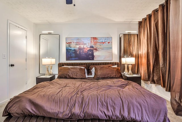 carpeted bedroom with a ceiling fan and a textured ceiling