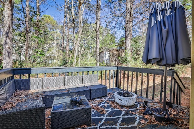 wooden terrace with an outdoor living space with a fire pit