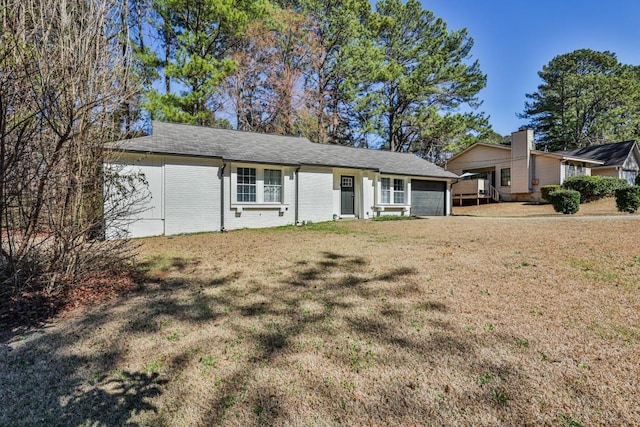 ranch-style home with a garage, brick siding, and a front yard