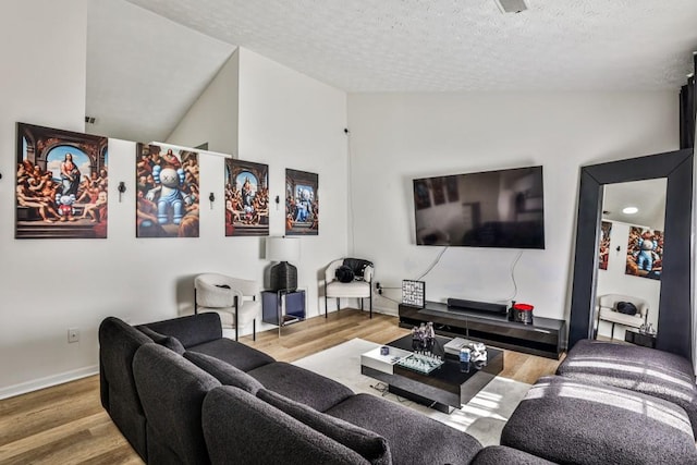 living room featuring a textured ceiling, baseboards, and wood finished floors