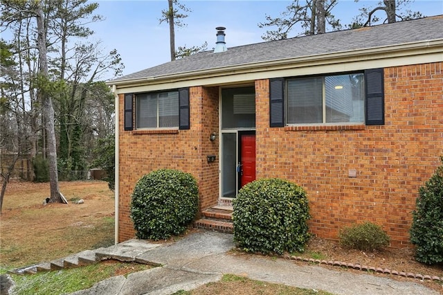 split foyer home with a front lawn and brick siding