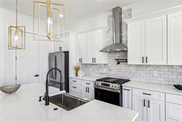 kitchen featuring wall chimney exhaust hood, appliances with stainless steel finishes, and crown molding