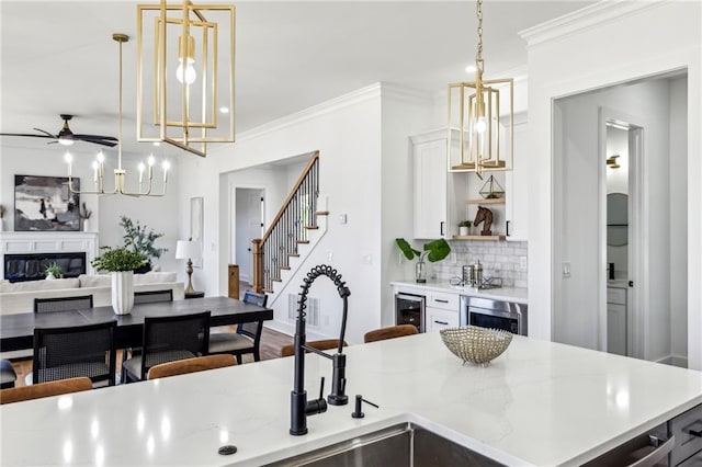 kitchen featuring ornamental molding, a glass covered fireplace, open floor plan, and backsplash