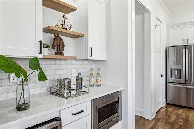 bar featuring stainless steel appliances, dark wood-style flooring, ornamental molding, and tasteful backsplash