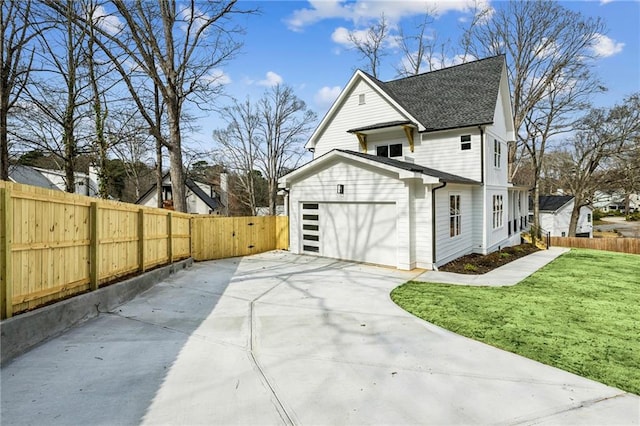 view of home's exterior with a garage, concrete driveway, a yard, and fence