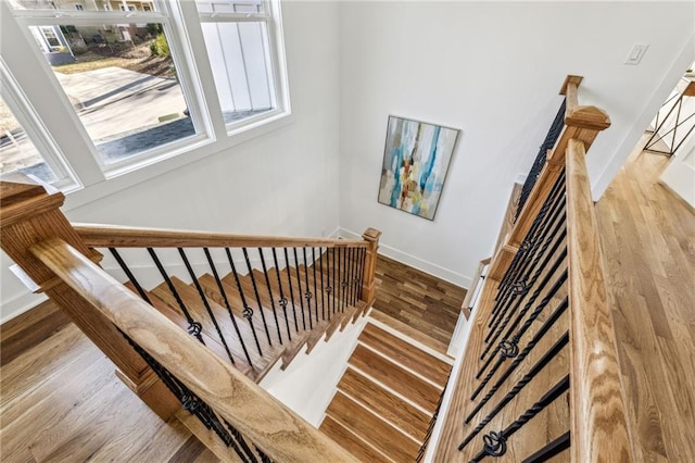 stairs featuring wood finished floors and baseboards